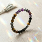 Load image into Gallery viewer, Multicolored beaded bracelet on a textured surface with rainbow