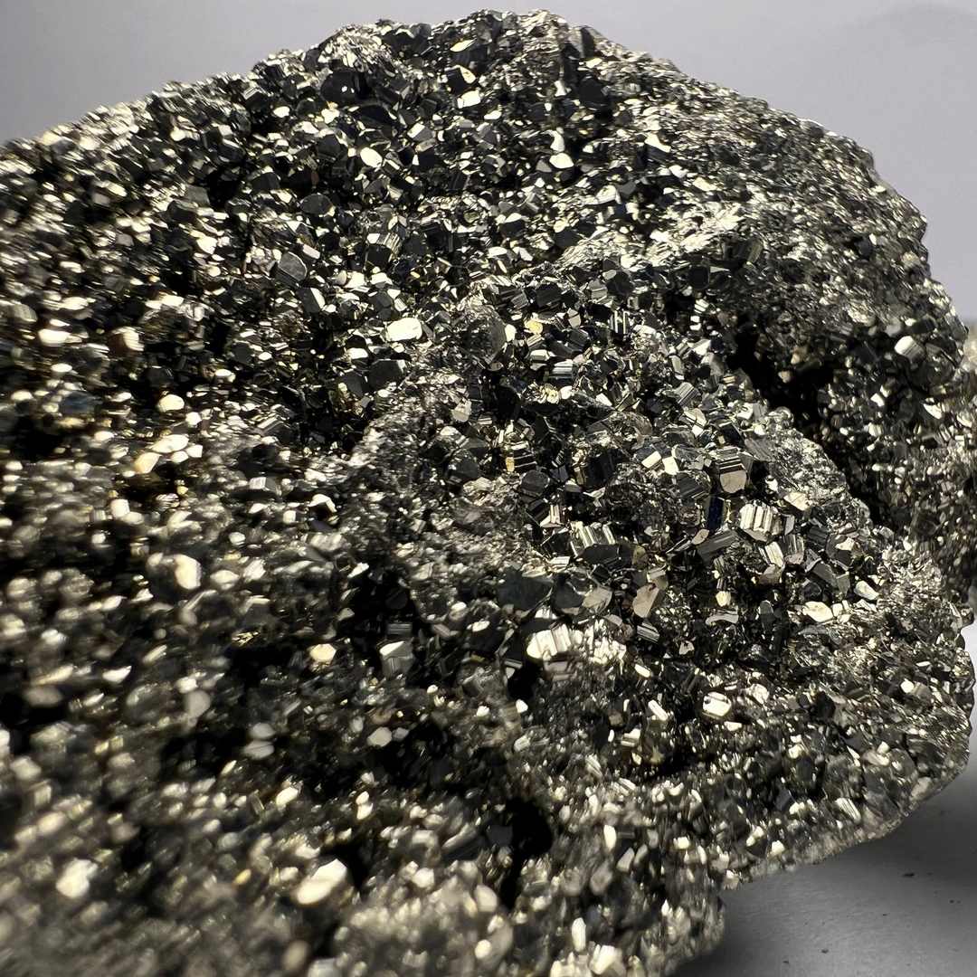 Close-up of a pyrite rock with a gray background